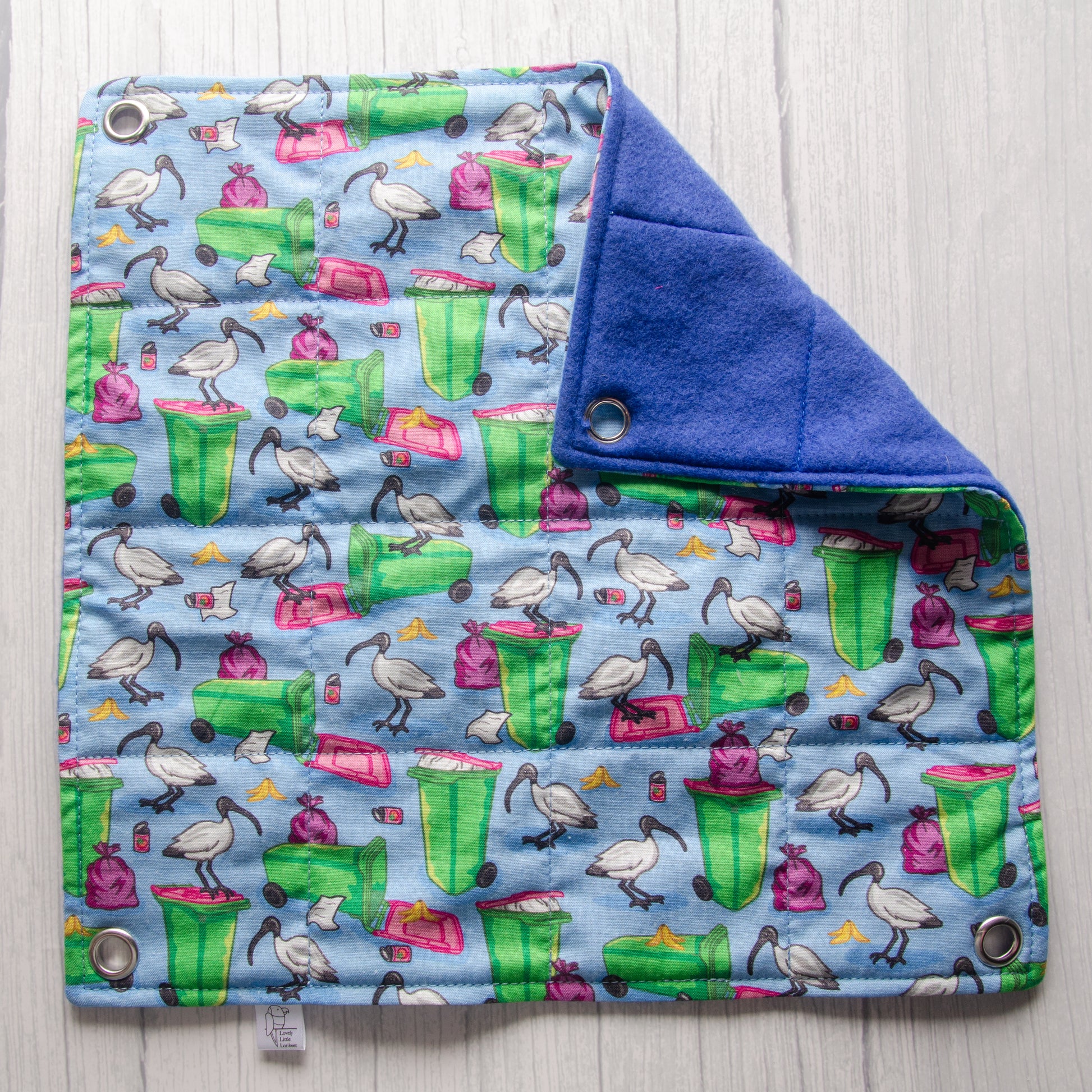 blue flat rat hammock with bin chicken and wheely bin pictures, folded at corner to show plain blue fleece.