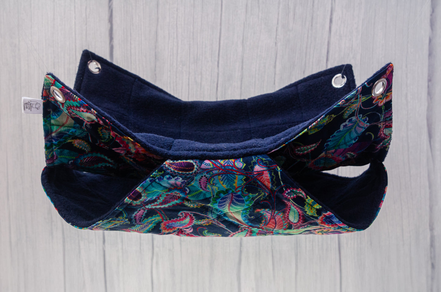 Double rat hammock suspended in air, navy paisley pattern on fabric with 10mm eyelets in each corner