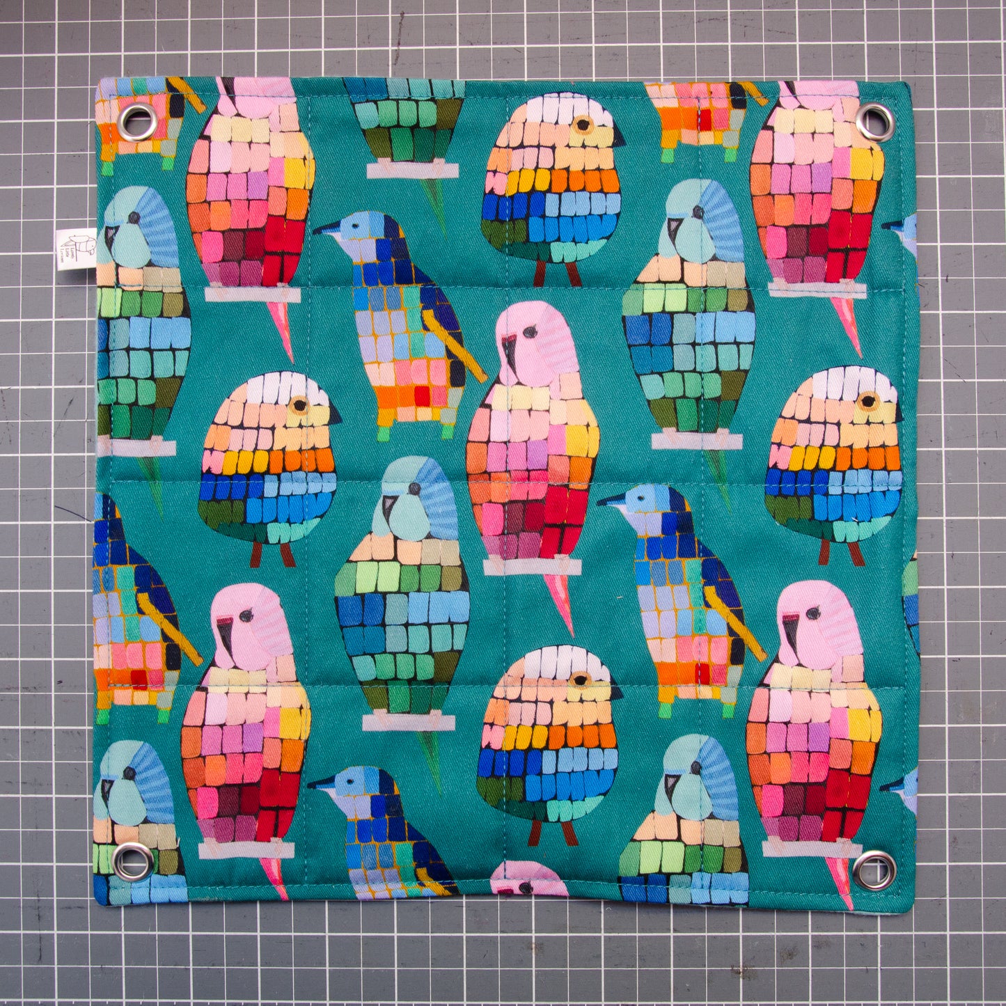 Flat hammock, flat lay, colourful birds in a mosaic pattern, grommets in corners.
